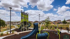 A playground with a slide, climbing structures, and exercise equipment.