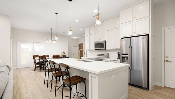 A modern kitchen with a large island, white cabinetry, stainless steel appliances, and pendant lighting. - GREAT LOCATION  Beautiful 2-bedroom house in Mission (Mission)