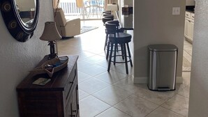 A hotel room with a large mirror, a wooden dresser, a TV, and a balcony with chairs. - Stunning, updated lakefront 2-bedroom condo.  14x40 boat slip available for rent (Osage Beach)