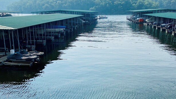 A marina with docked boats and a covered walkway. - Stunning, updated lakefront 2-bedroom condo.  14x40 boat slip available for rent (Osage Beach)