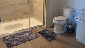 Ein modernes Badezimmer mit Duschkabine, Toilette und Schrank.