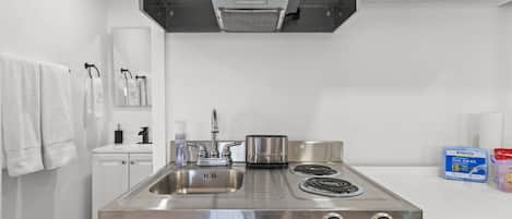 A kitchen with stainless steel appliances, including a Summit brand stove and a sink.