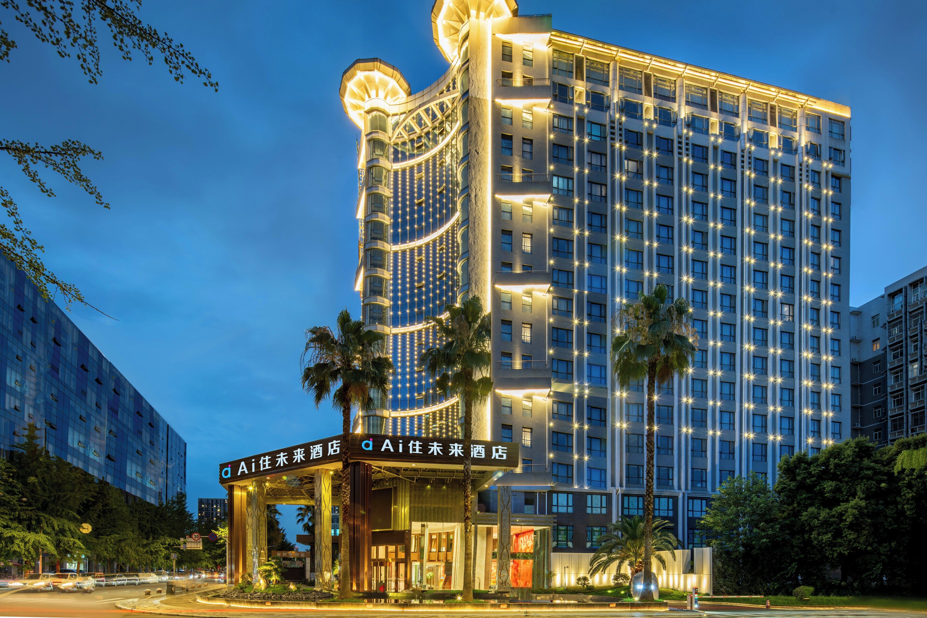A high-rise hotel with a modern design, featuring a prominent entrance with illuminated signage.
