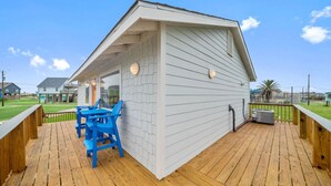 Een klein, wit gebouw met een schuin dak en een houten terras.