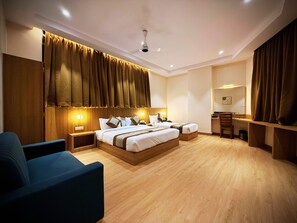A modern hotel room with a large bed, bedside tables, a desk, and a chair. - Hotel Alfa Suites (Mumbai)