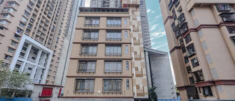 A multi-story hotel with a modern design, featuring balconies and large windows.