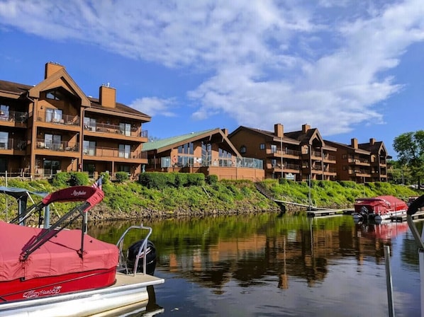A waterfront hotel with multiple-story buildings, balconies, and a dock with boats.