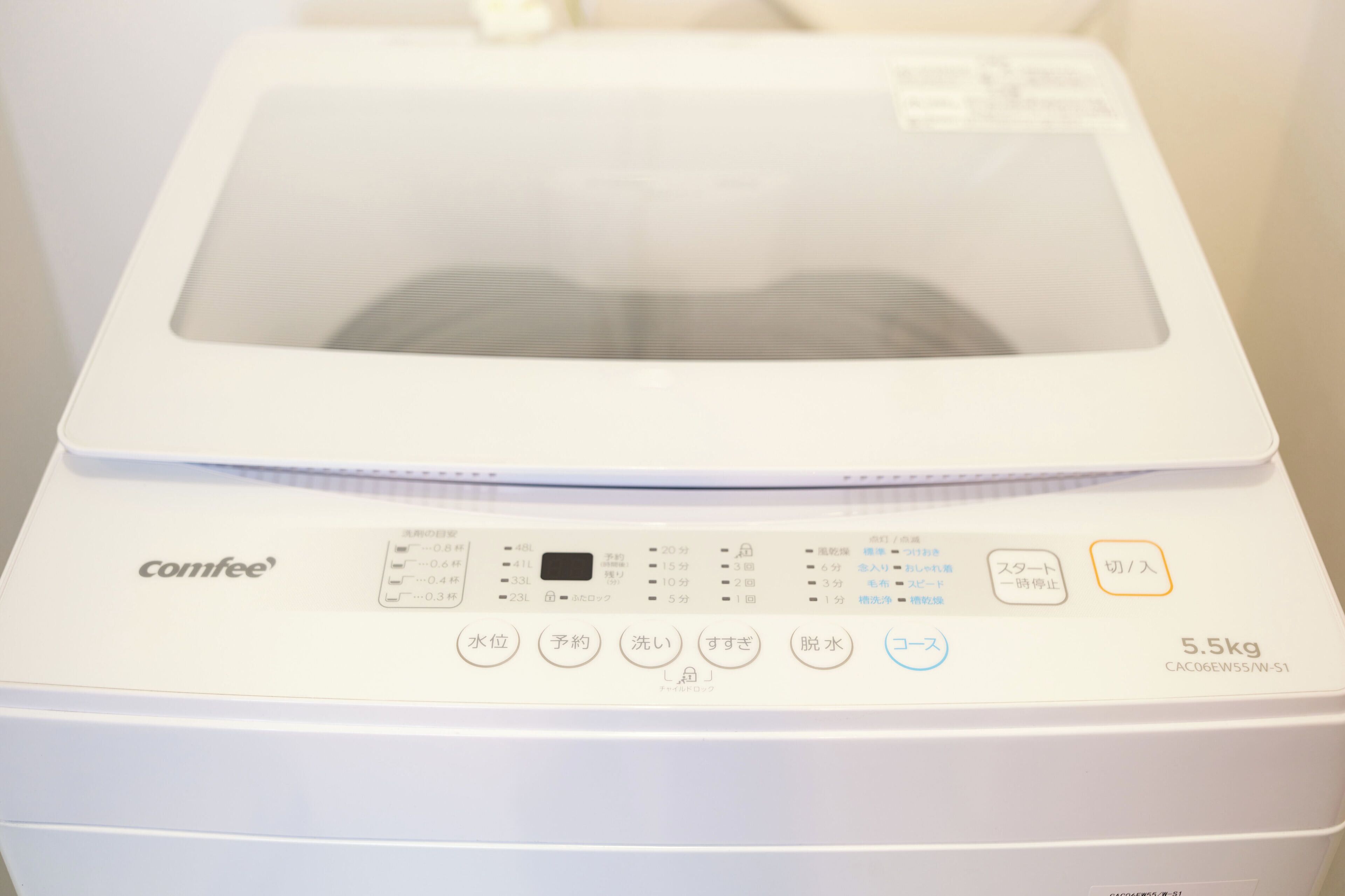 A white coffee maker with a digital display and multiple buttons for settings.