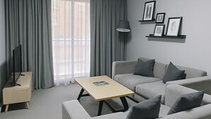 A modern living room with a sofa, coffee table, and a TV stand. - Modern Apartment in Sydney CBD Heart (Sydney)