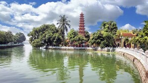 A pagoda-style tower surrounded by lush greenery and a calm river. - Ly Home Tay Ho Ha Noi  (Hanoi)