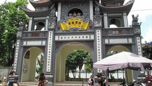 A traditional Chinese gate with ornate carvings and a yellow banner. - Ly Home Tay Ho Ha Noi  (Hanoi)