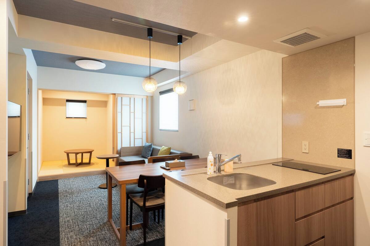 A modern kitchen with a central island, built-in cabinets, and pendant lighting.