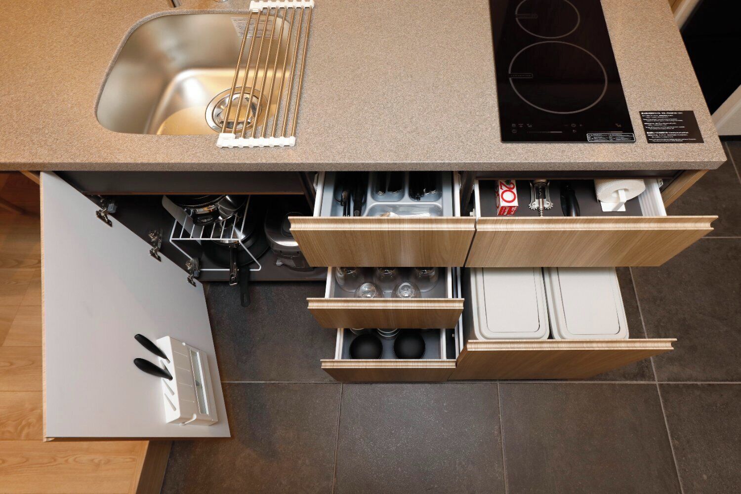 A kitchen with a sink, stove, and wooden cabinetry.