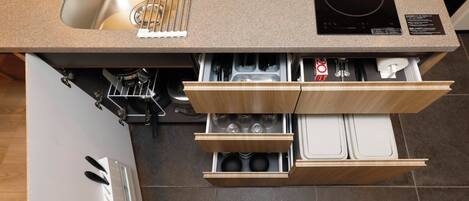 A kitchen with a sink, stove, and wooden cabinetry.
