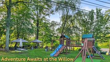 A playground with various play structures including a slide, swings, and a climbing area.