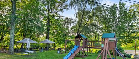 A playground with various play structures including a slide, swings, and a climbing area.