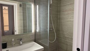 A modern bathroom with a glass-enclosed shower, a white sink, and a mirror above it. - Modern Apartment - 1br- 2P - Montreuil (Montreuil)