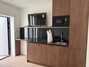 A modern kitchen with a microwave, a flat-screen TV, and a sink. - Charming Apartment - 2BR - 4P - Montreuil (Montreuil)