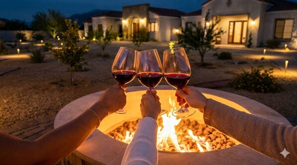 Three people toasting with wine glasses around a fire pit. - Baja Toscana Rancho Olivares (Valle de Guadalupe)