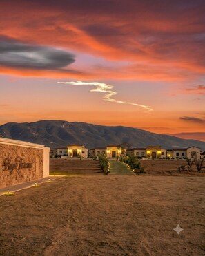 A desert landscape with a row of houses at sunset. - Baja Toscana Rancho Olivares (Valle de Guadalupe)