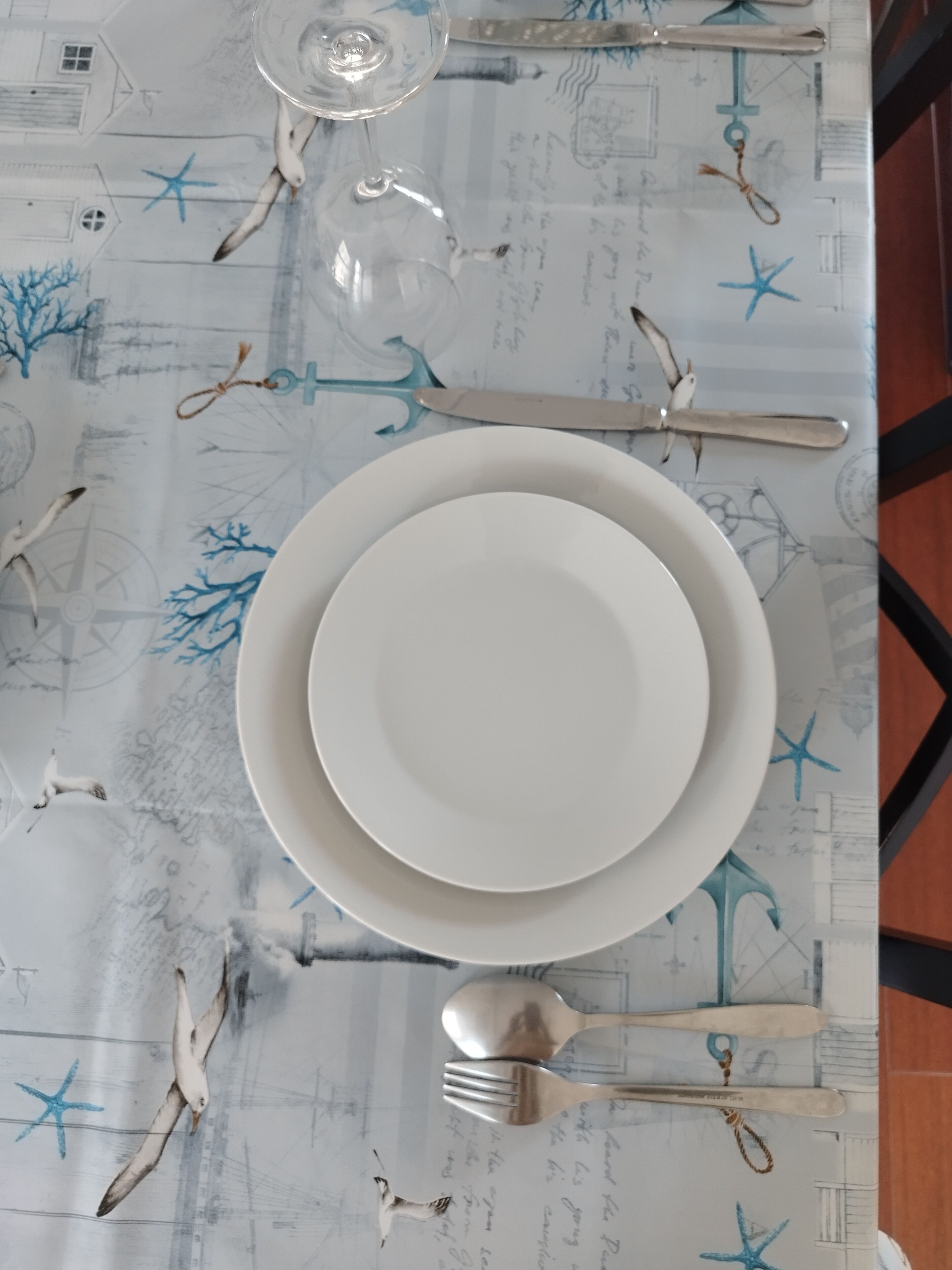 A table set with plates, cutlery, and a glass.