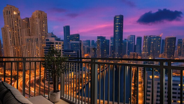 A balcony with a view of a cityscape at dusk, featuring high-rise buildings and a river. - LUX 52 42 Deluxe Marina View Suite 3 (Dubai)
