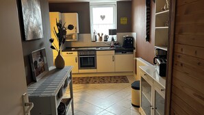A compact kitchen with a stove, oven, and coffee maker. - Olivia Vacation Rental in Hönow (Hoppegarten)