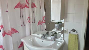 Un bagno con lavandino, specchio e mobili bianchi.