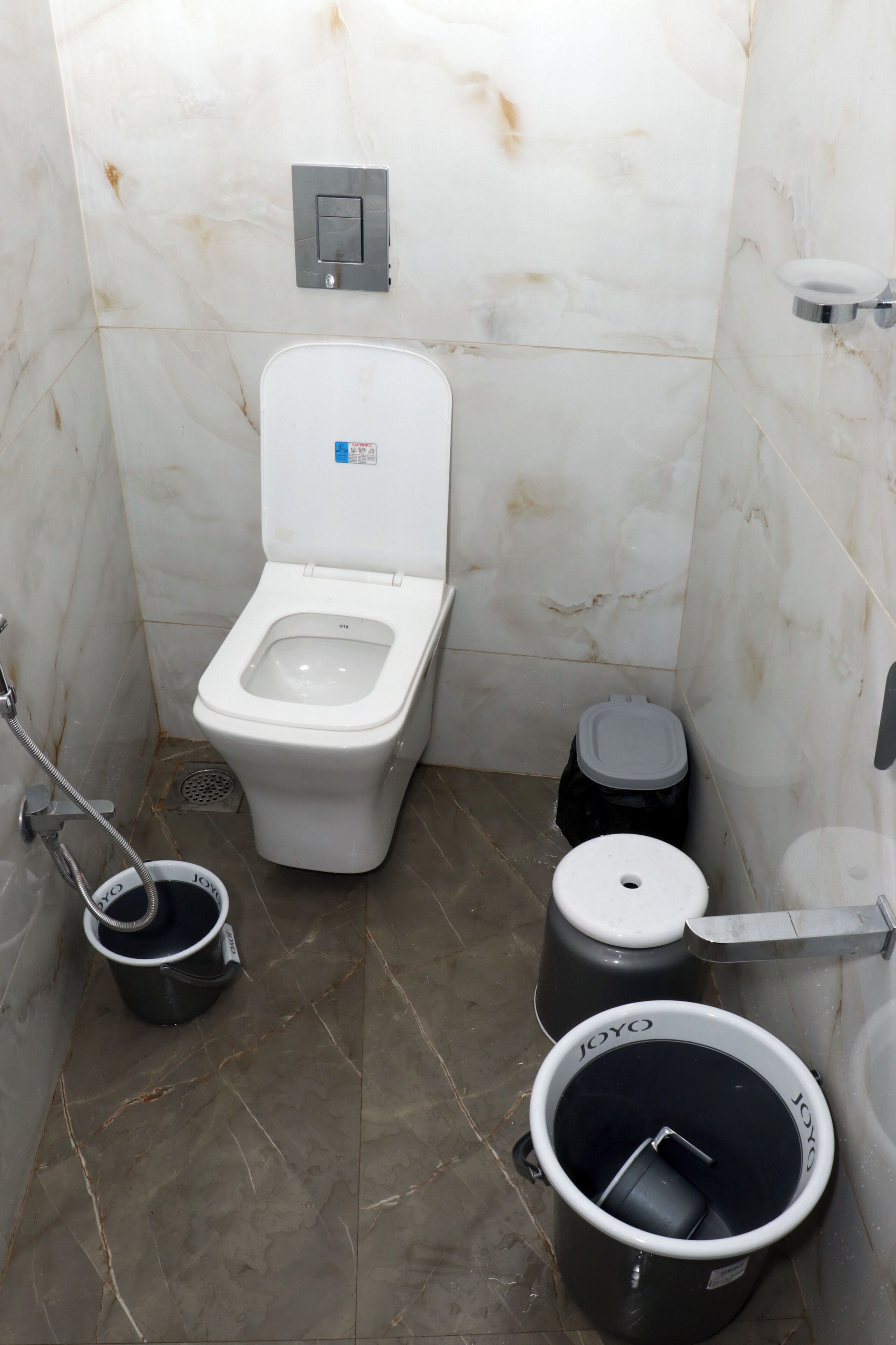 Un baño pequeño con azulejos, un inodoro, un bidé y botes de basura.