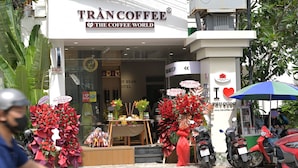 Un café appelé «
Trân Coffee
» avec une enseigne indiquant : «
Le monde du café
».