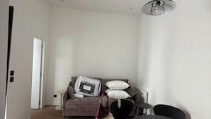 A modern living room with a sofa, a coffee table, and a dining table. - Modern Apartment - 1br-4p - Montreuil (Montreuil)