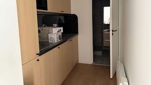 A compact kitchen with a microwave, a coffee maker, and a toaster on the counter. - Modern Apartment - 1br-4p - Montreuil (Montreuil)
