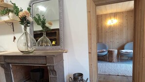 A rustic interior with a fireplace, a mirror, and a wooden wall. - Au Mont Chablis (Champagnole)