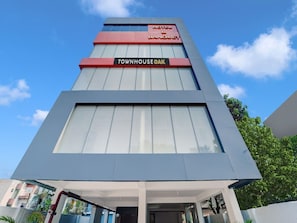 A modern hotel with a prominent sign for 'TOWNHOUSE OAK HOTEL & BANQUET' and a large glass facade. - Deluxe The Dev Regency (Patna)