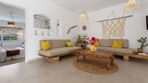 A modern living room with a sofa, coffee table, and decorative wall art. - Holiday Home 'Casa Azul' with Sea View, Private Terrace & Wi-Fi (Las Palmas)