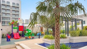 A children's play area with slides and a small pool. - FIRST CLASS | Studio | Minimalist Chic Retreat (JVC)