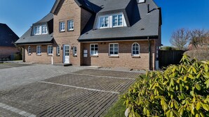 Un bâtiment en briques de deux étages, doté d’un toit à forte pente, de nombreuses fenêtres et d’une allée pavée.