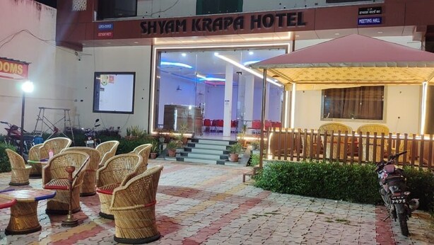 A hotel entrance with wicker furniture and a covered seating area.