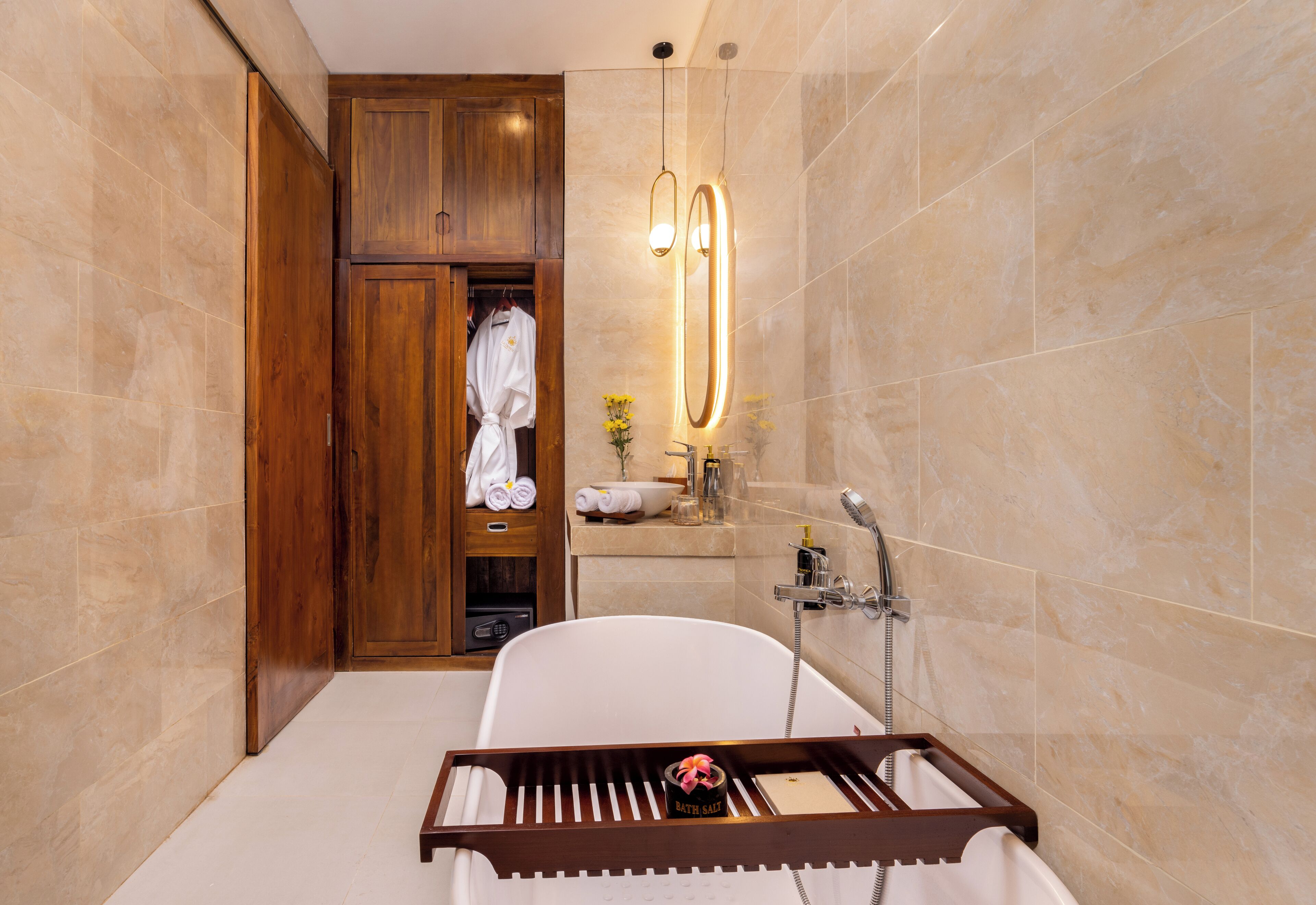 Ein modernes Badezimmer mit einer freistehenden Badewanne, Holzschränken, einem Waschtisch mit Spiegel und einem Handtuchhalter.