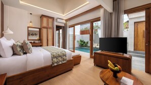 A modern bedroom with a bed, TV, and a small table with fruit. - La Tropica Canggu Bali (Buduk)
