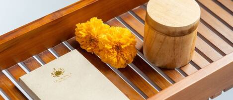 A wooden tray with a white box and a wooden container on a white surface.