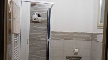 Regadera, secadora de cabello, bidet, toallas