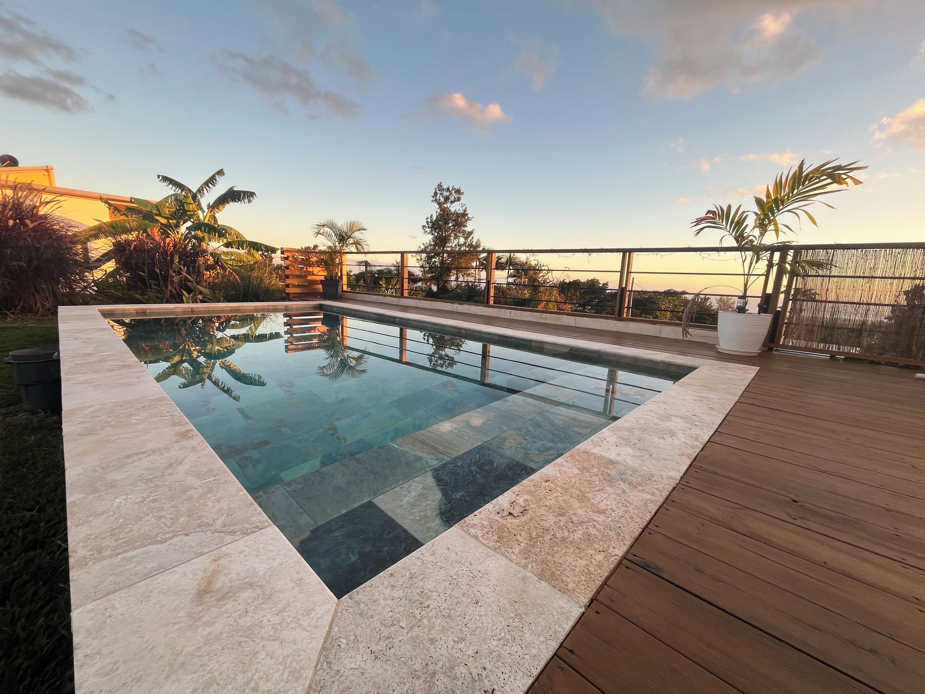 Ein rechteckiger Pool mit umlaufender Holzterrasse.