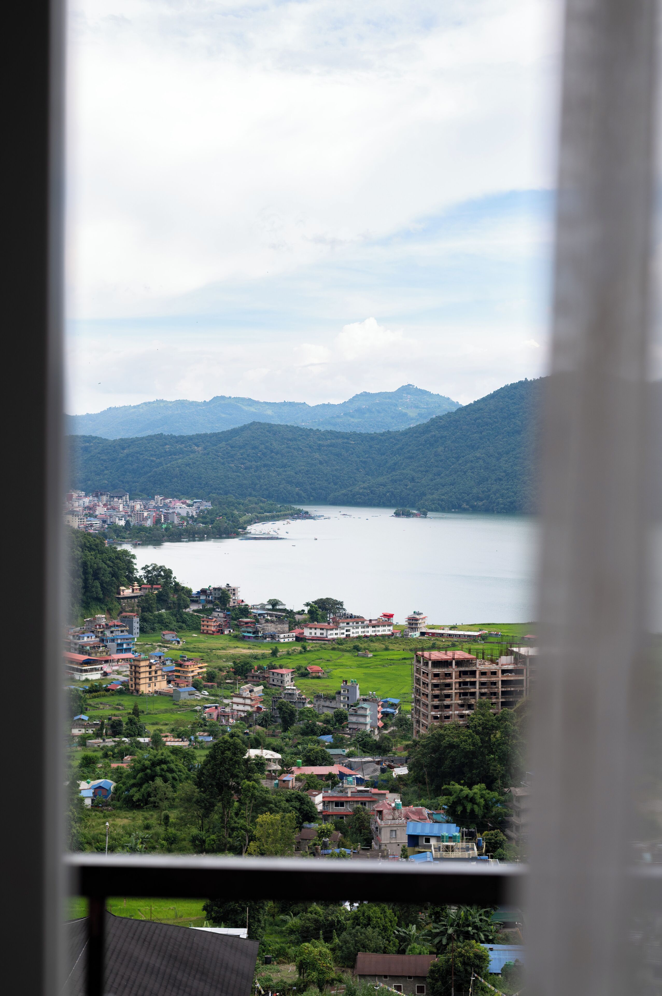 Vista de un lago con edificios circundantes y montañas.