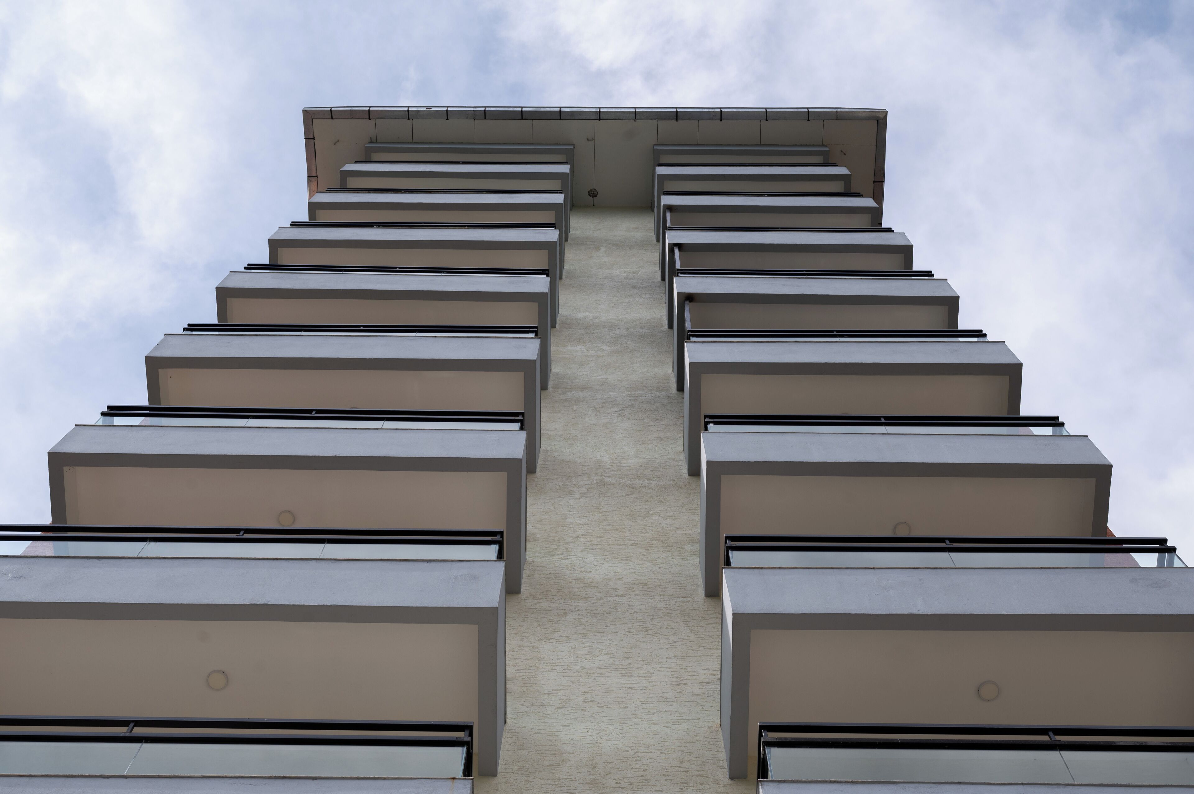 Ein modernes Gebäude mit einer symmetrischen Fassade und mehreren Balkonen.