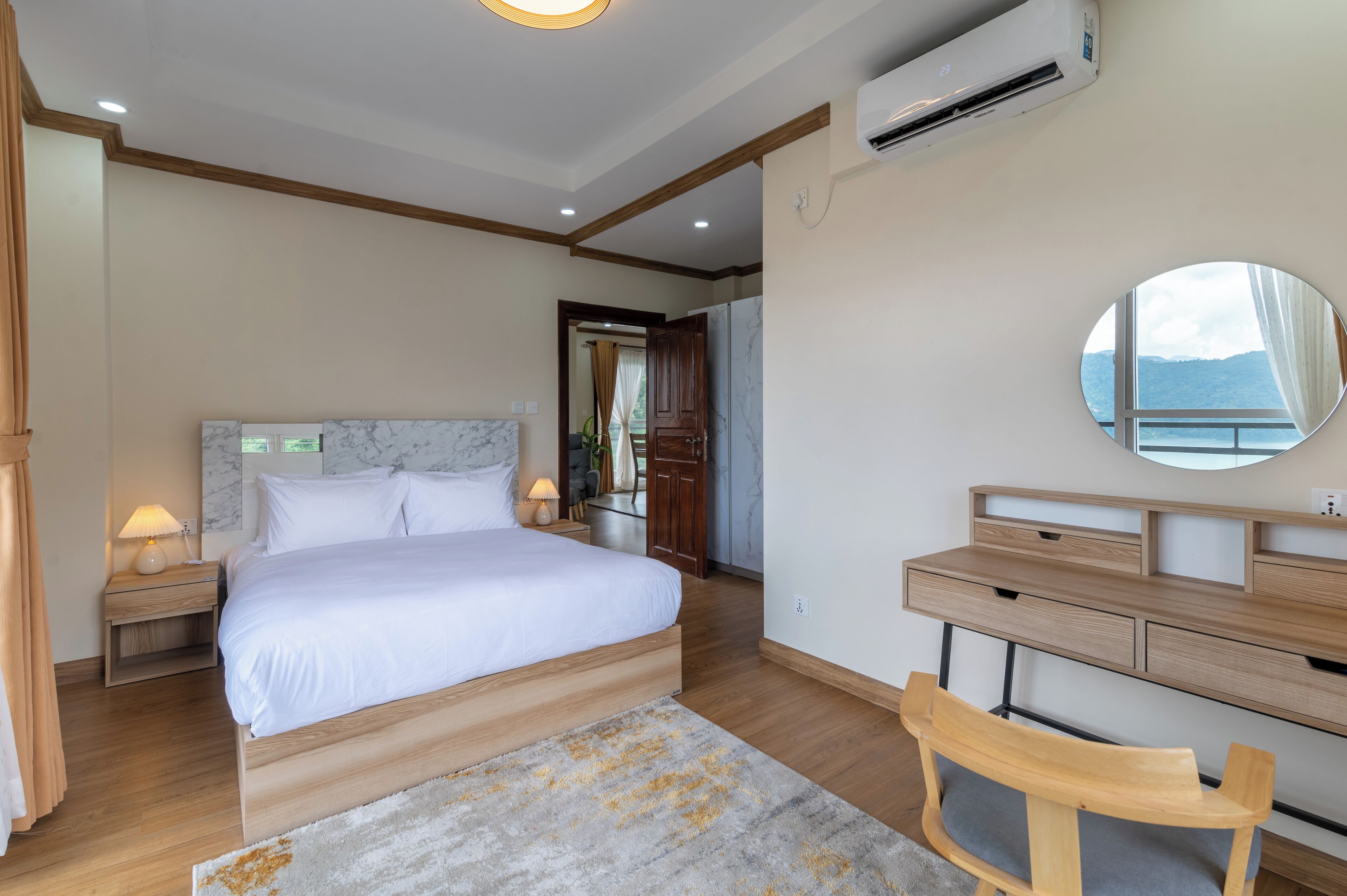 Un dormitorio con cama, mesita de noche, lámpara y escritorio con silla.