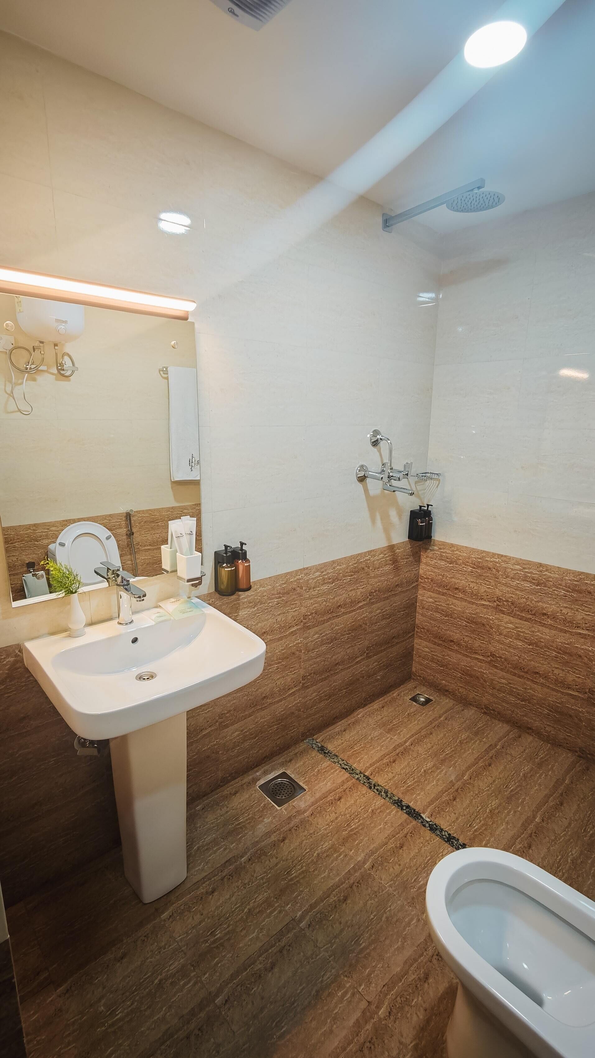 A modern bathroom with a white sink, a toilet, and a shower area.