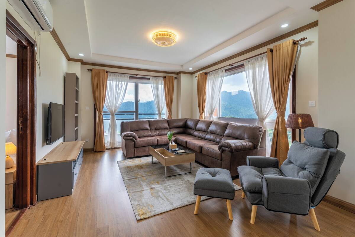 A modern living room with a sectional sofa, a coffee table, and a grey armchair.