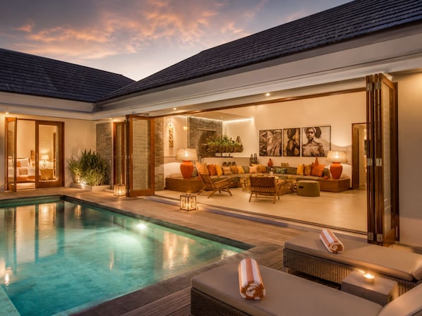 Una zona junto a la piscina con asientos, piscina y vistas al cielo.