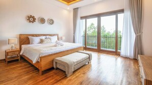 A spacious bedroom with a large bed, wooden flooring, and a balcony with curtains. - Luxurious 6 BR With Sea View, 5 Mins to Savaya (Pecatu)